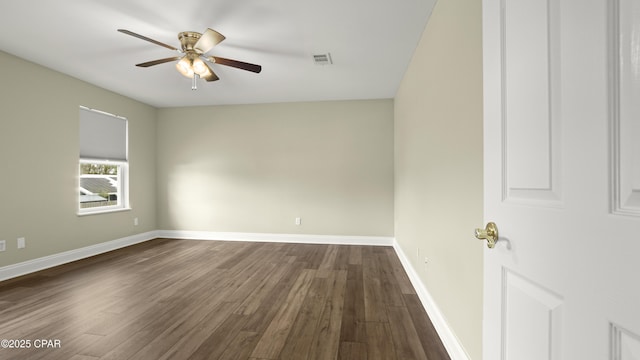 spare room featuring dark wood finished floors, visible vents, ceiling fan, and baseboards