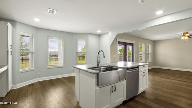 kitchen featuring a kitchen island with sink, a sink, dishwasher, white cabinets, and dark wood finished floors