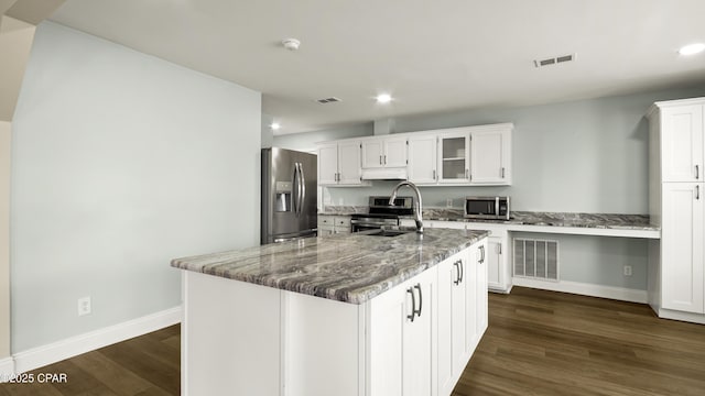 kitchen featuring a sink, dark wood-style flooring, stainless steel appliances, and baseboards