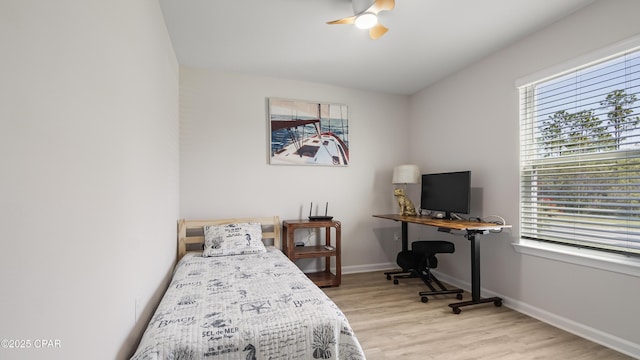 bedroom with a ceiling fan, baseboards, and light wood-type flooring