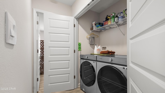 washroom featuring laundry area, light wood-style flooring, and washer and clothes dryer