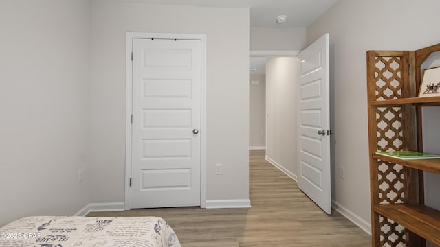 bedroom with baseboards and light wood finished floors