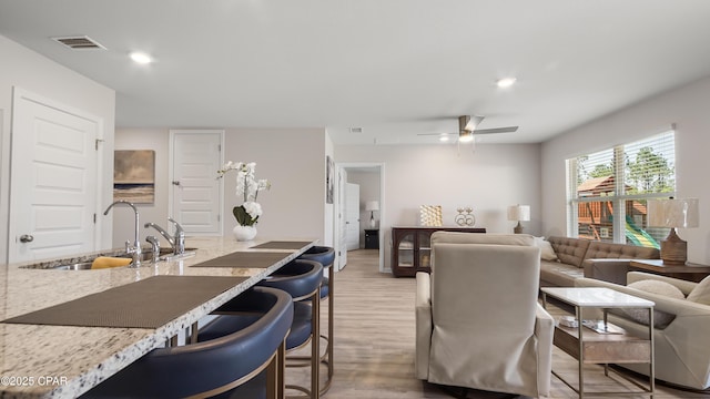 living area featuring visible vents, recessed lighting, light wood-style flooring, and ceiling fan