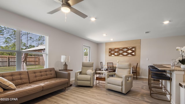 living room with a ceiling fan, visible vents, baseboards, light wood finished floors, and recessed lighting