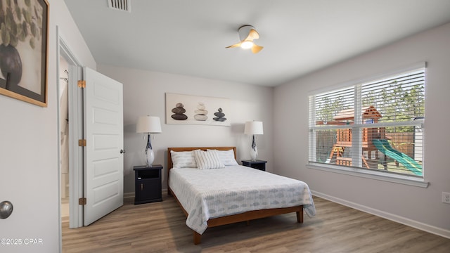 bedroom featuring baseboards, wood finished floors, and visible vents