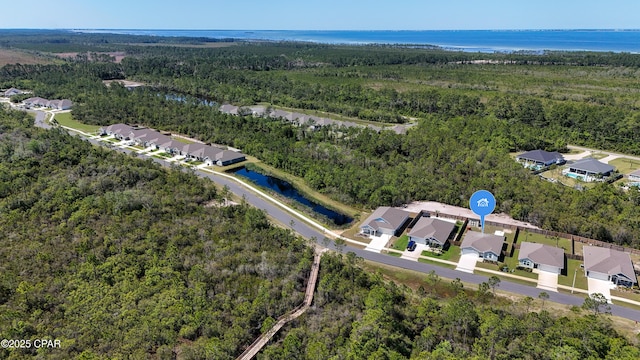 aerial view featuring a water view, a residential view, and a forest view