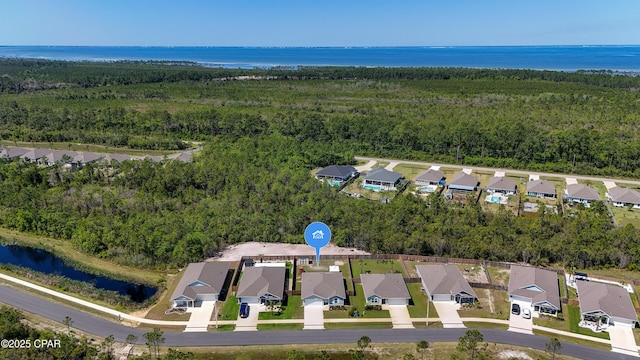 aerial view featuring a water view, a view of trees, and a residential view