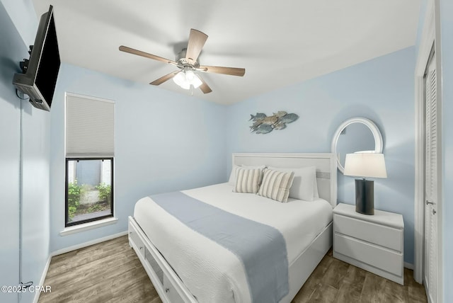 bedroom with wood finished floors, baseboards, and ceiling fan