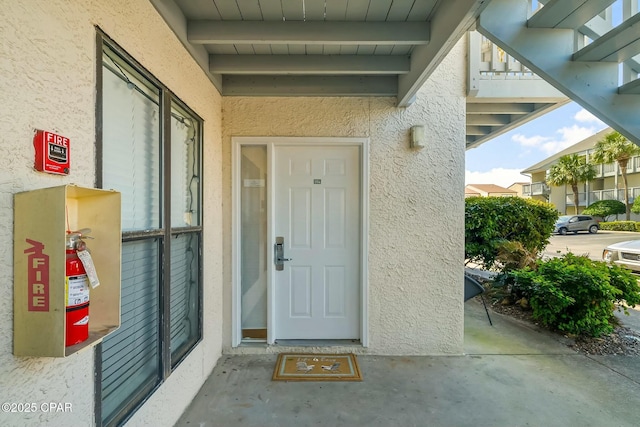 property entrance with stucco siding