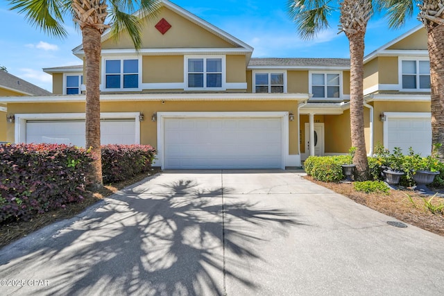 view of front of home with an attached garage, driveway, and stucco siding
