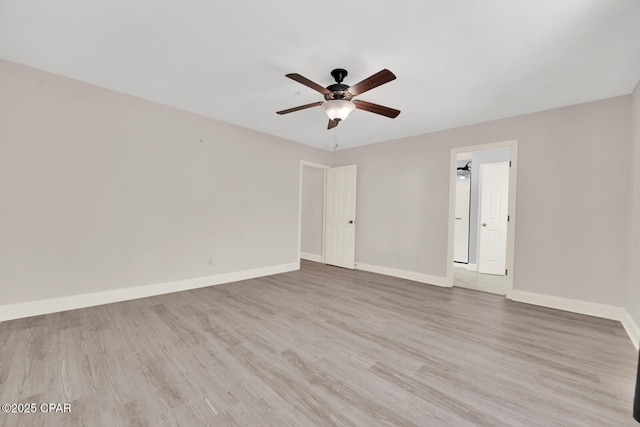 spare room featuring baseboards, a ceiling fan, and wood finished floors