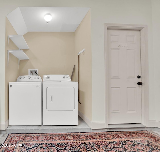 laundry area with laundry area, separate washer and dryer, and baseboards