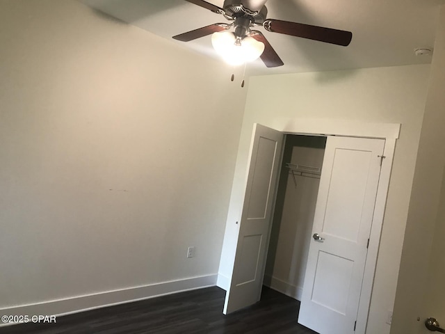 unfurnished bedroom featuring dark wood-type flooring, a closet, ceiling fan, and baseboards