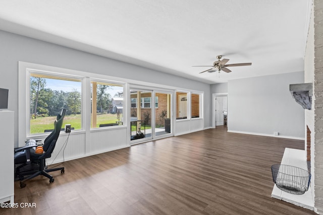 living room with ceiling fan, baseboards, and dark wood finished floors