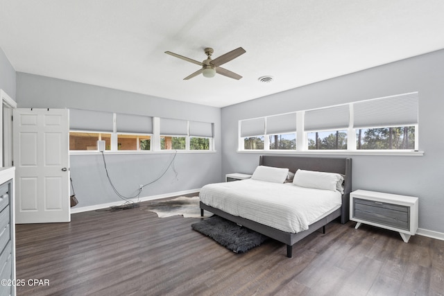 bedroom with ceiling fan, visible vents, baseboards, and dark wood-style floors