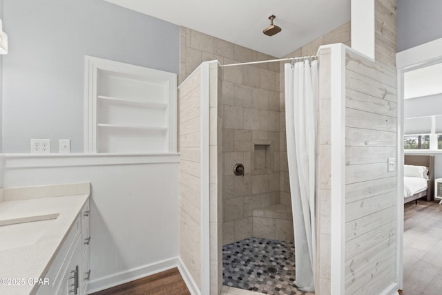bathroom featuring ensuite bathroom, a stall shower, wood finished floors, and vanity