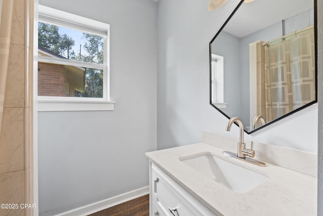 full bath with baseboards, a shower with shower curtain, vanity, and wood finished floors