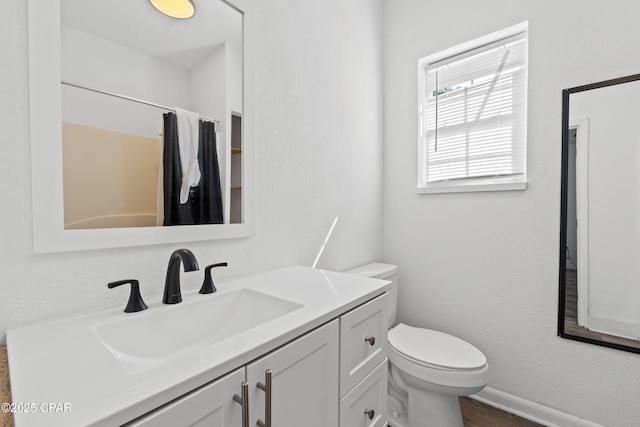 bathroom with toilet, curtained shower, and vanity