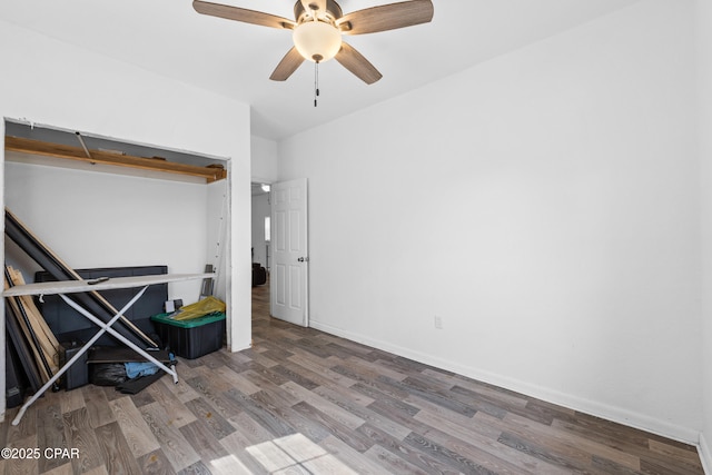 interior space featuring ceiling fan, wood finished floors, and baseboards
