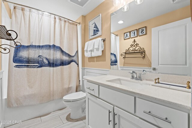 15928 Front Beach Rd Unit 3 2005, Panama City Beach, FL 32413 - full bathroom featuring toilet, vanity, wainscoting, and shower / tub combo