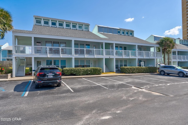 17670 Front Beach Rd Unit B8, Panama City Beach, FL 32413 - view of building exterior featuring stairs and uncovered parking