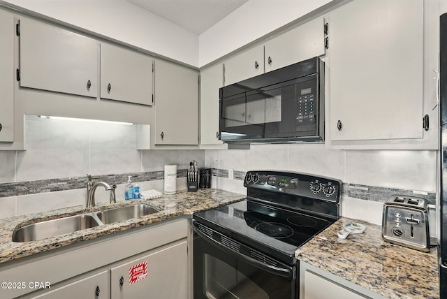 17670 Front Beach Rd Unit B8, Panama City Beach, FL 32413 - kitchen with light stone counters, a sink, backsplash, and black appliances