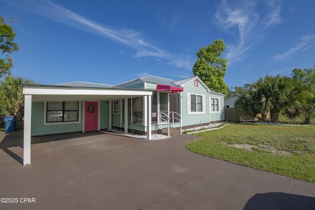 view of front facade featuring a front yard, metal roof, and aphalt driveway