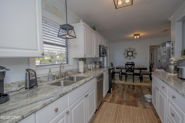 kitchen featuring light stone counters, appliances with stainless steel finishes, a sink, and white cabinetry
