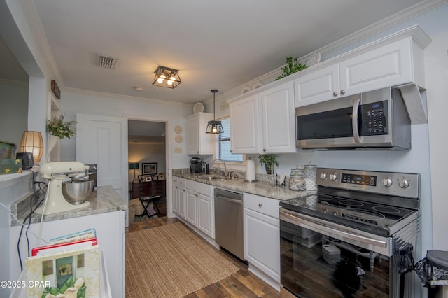 kitchen with white cabinets, appliances with stainless steel finishes, crown molding, and a sink