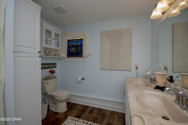 full bathroom with wood finished floors, visible vents, a sink, and toilet