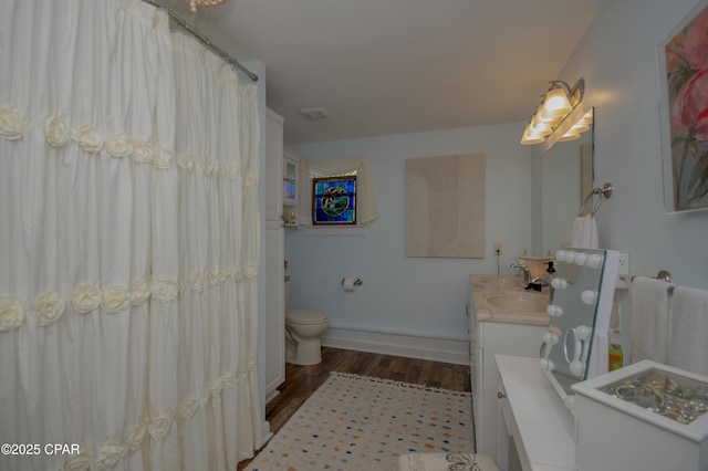 bathroom featuring wood finished floors, toilet, vanity, a shower with curtain, and baseboards
