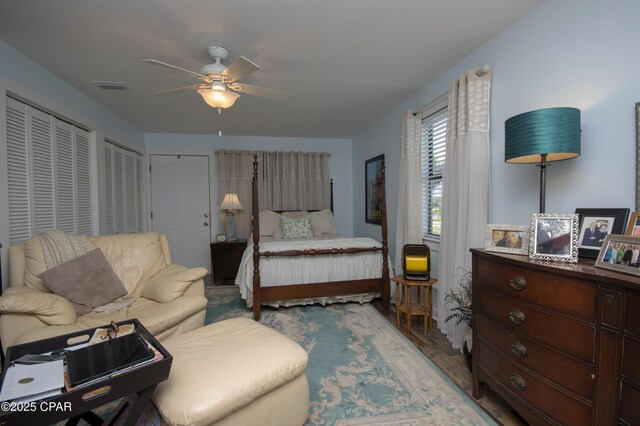 bedroom featuring wood finished floors, visible vents, and ceiling fan
