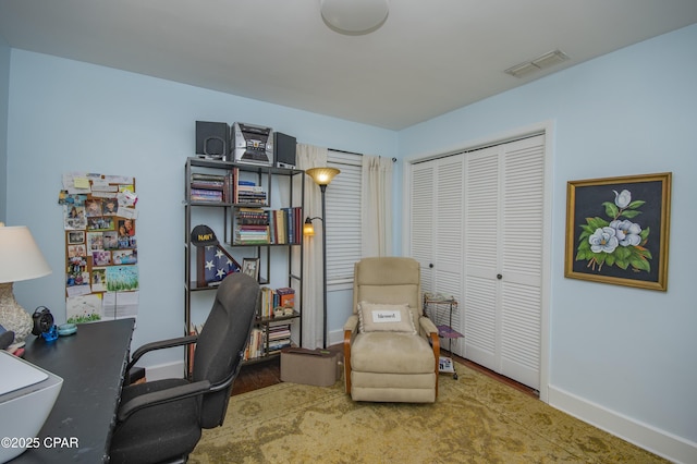 office space featuring wood finished floors, visible vents, and baseboards