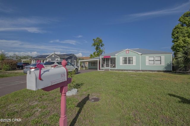 ranch-style home featuring a front yard and metal roof