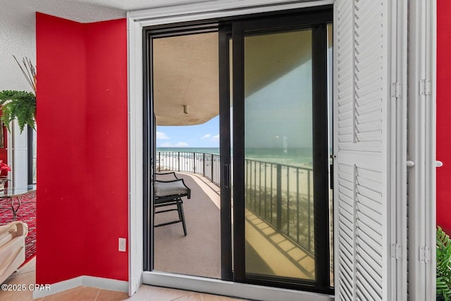 11619 Front Beach Rd Unit 201, Panama City Beach, FL 32407 - doorway featuring a water view, baseboards, and tile patterned flooring