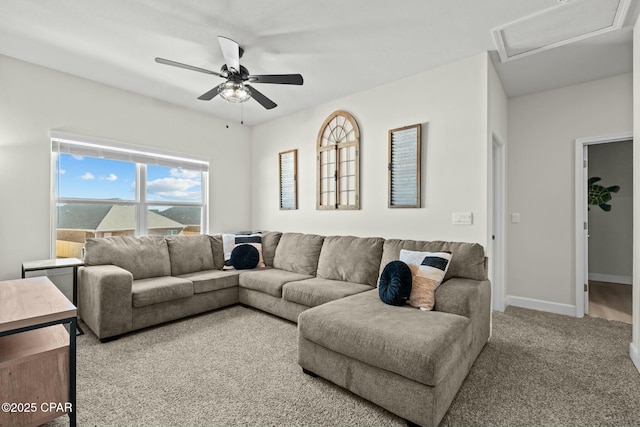 living area with baseboards, a ceiling fan, and carpet