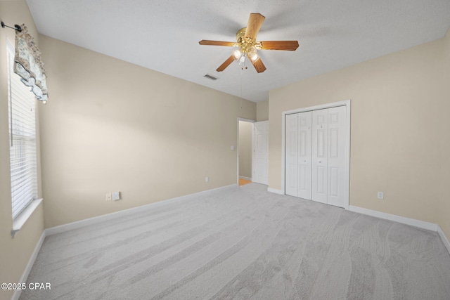 unfurnished bedroom featuring baseboards, carpet, and visible vents