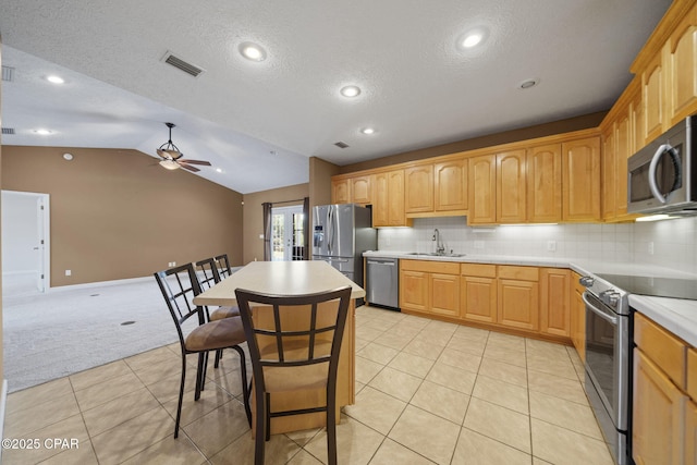 kitchen with a sink, ceiling fan, appliances with stainless steel finishes, a textured ceiling, and light colored carpet