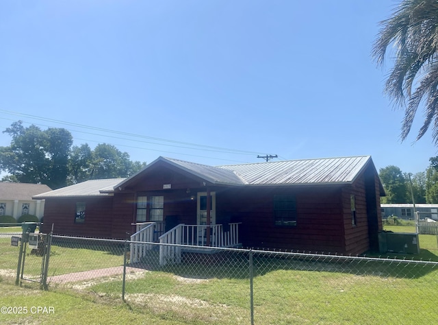 ranch-style house with metal roof, fence private yard, and a front lawn