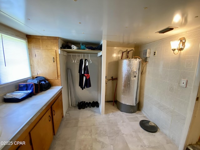 bathroom with visible vents and tile walls