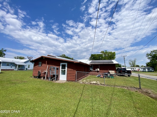 exterior space featuring a yard, fence, and an outbuilding