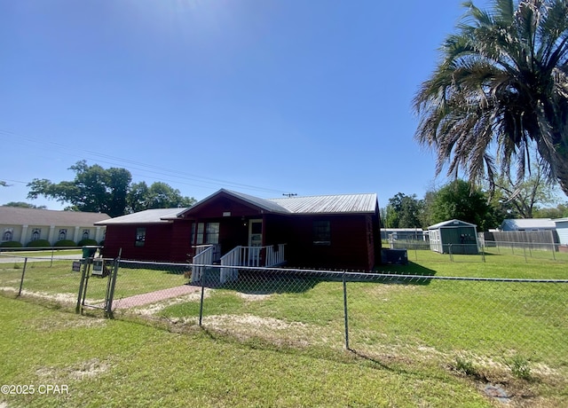 view of front facade with a front yard, metal roof, and fence private yard