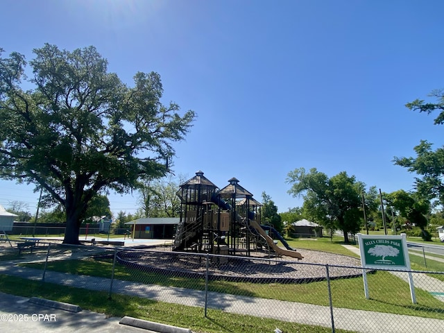 communal playground featuring a yard and fence