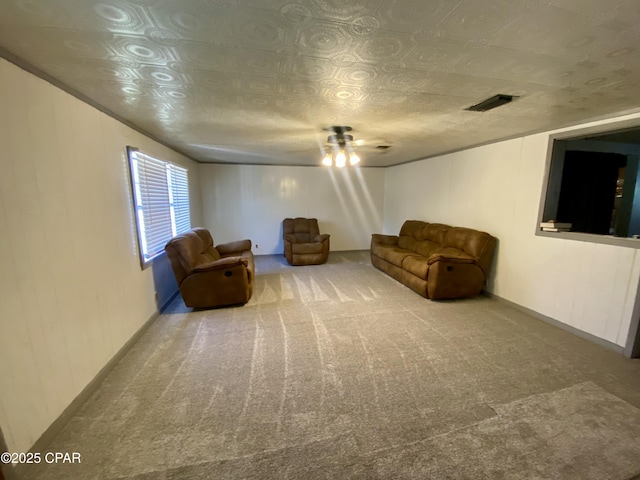 sitting room with carpet flooring, visible vents, and an ornate ceiling