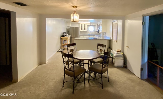 dining space with visible vents and light carpet