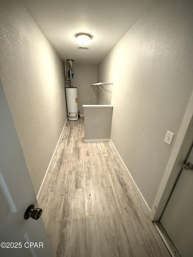 1421 S Berthe Ave, Panama City, FL 32404 - interior space featuring water heater, baseboards, a textured wall, and wood finished floors
