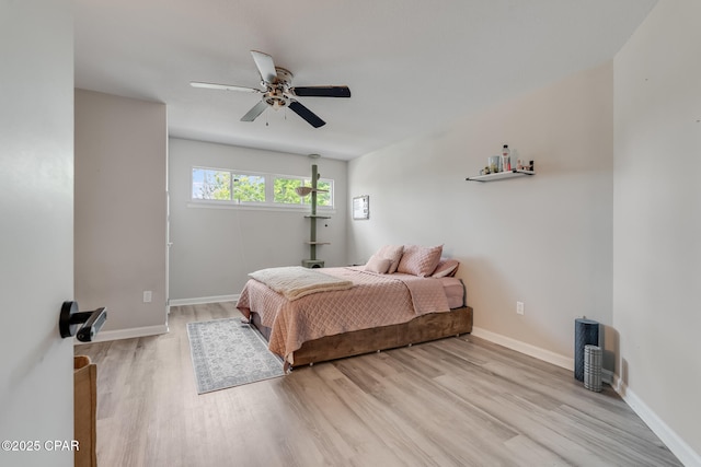 bedroom featuring ceiling fan, baseboards, and light wood-style floors