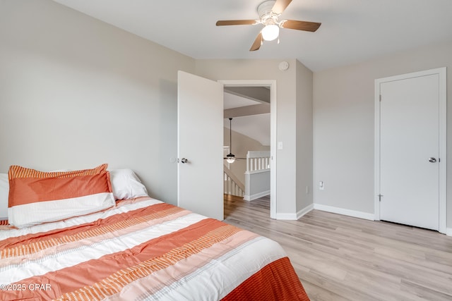 bedroom featuring light wood finished floors, baseboards, and ceiling fan