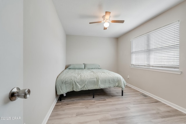 bedroom featuring wood finished floors, visible vents, and baseboards