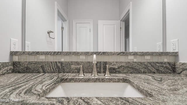 bathroom with vanity and tasteful backsplash